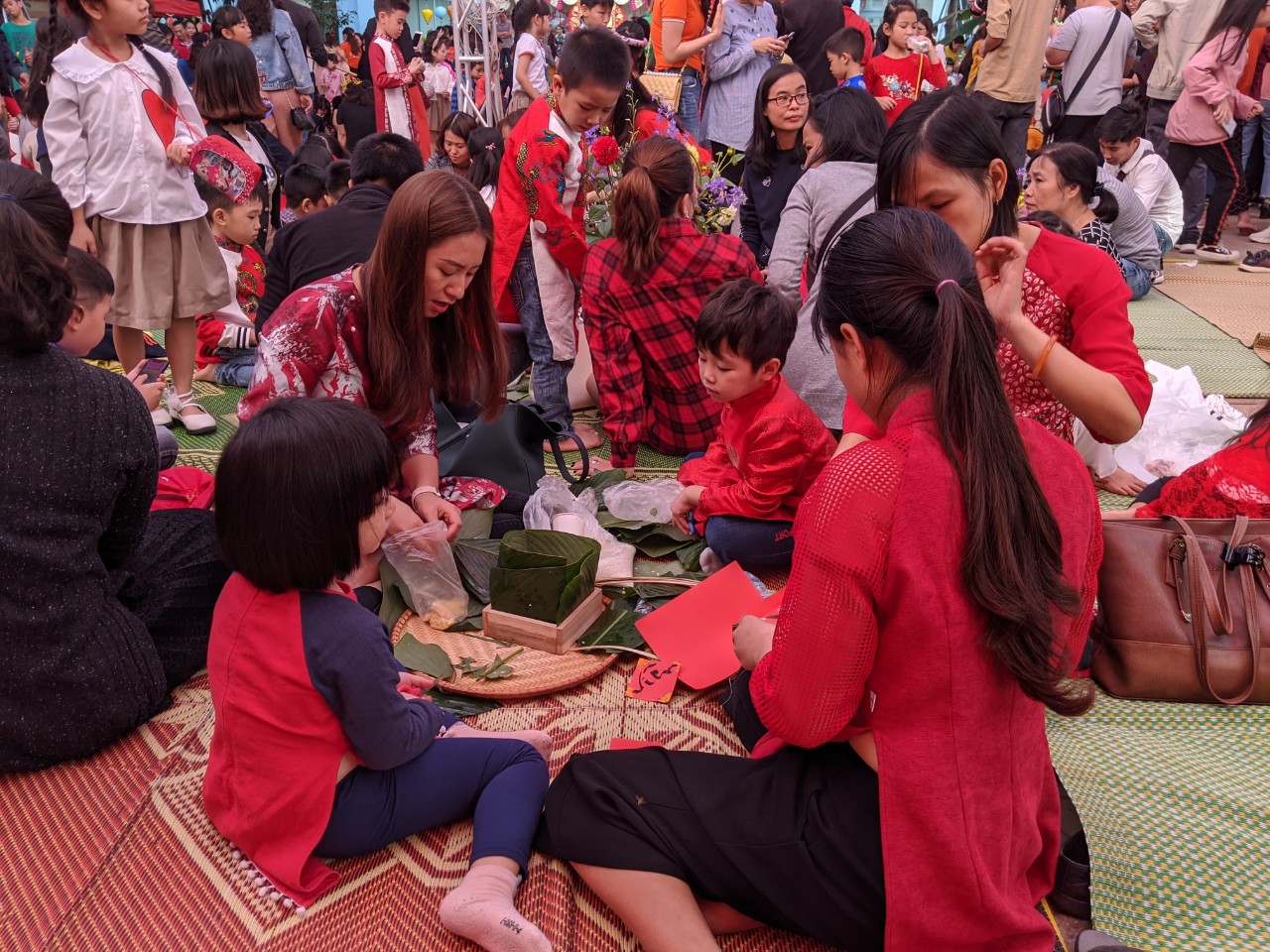 Các phụ huynh vừa gói bánh, vừa kể câu chuyện về sự tích bánh chưng bánh giày cho các con