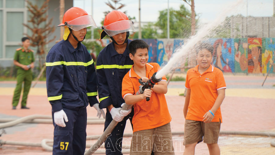 Học sinh Trường Tiểu học, THCS và THPT FPT Hà Nam được thực hành sử dụng vòi phun nước chữa cháy. Ảnh: Khánh Chi
