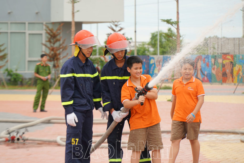 Học sinh được tập huấn cách sử dụng vòi cứu hỏa.