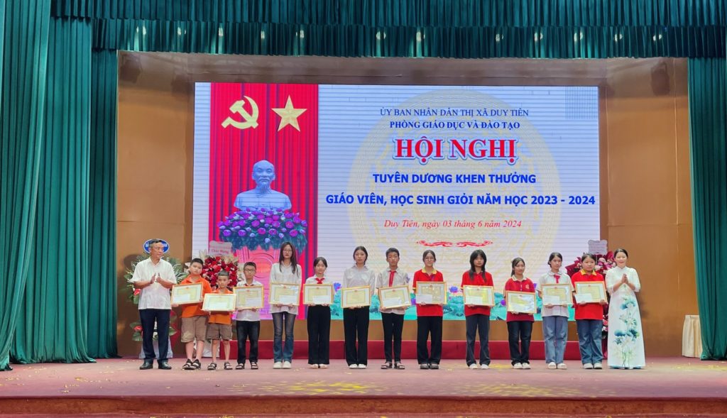 Học sinh FPT School Hà Nam với sắc áo cam nhà F trên sân khấu nhận thưởng.